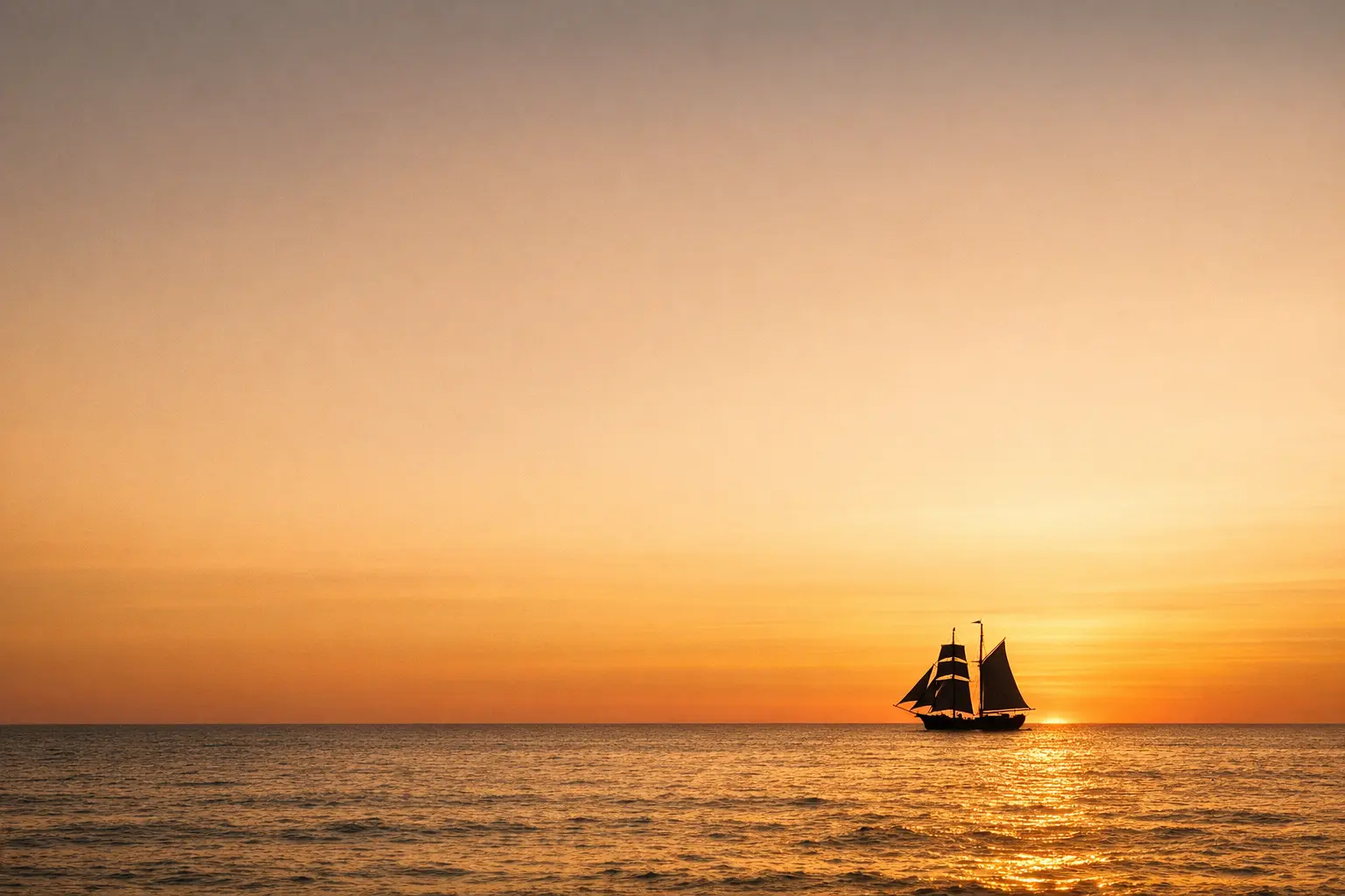 Sailing ship silhouette on the horizon at golden hour symbolizing freedom and adventure